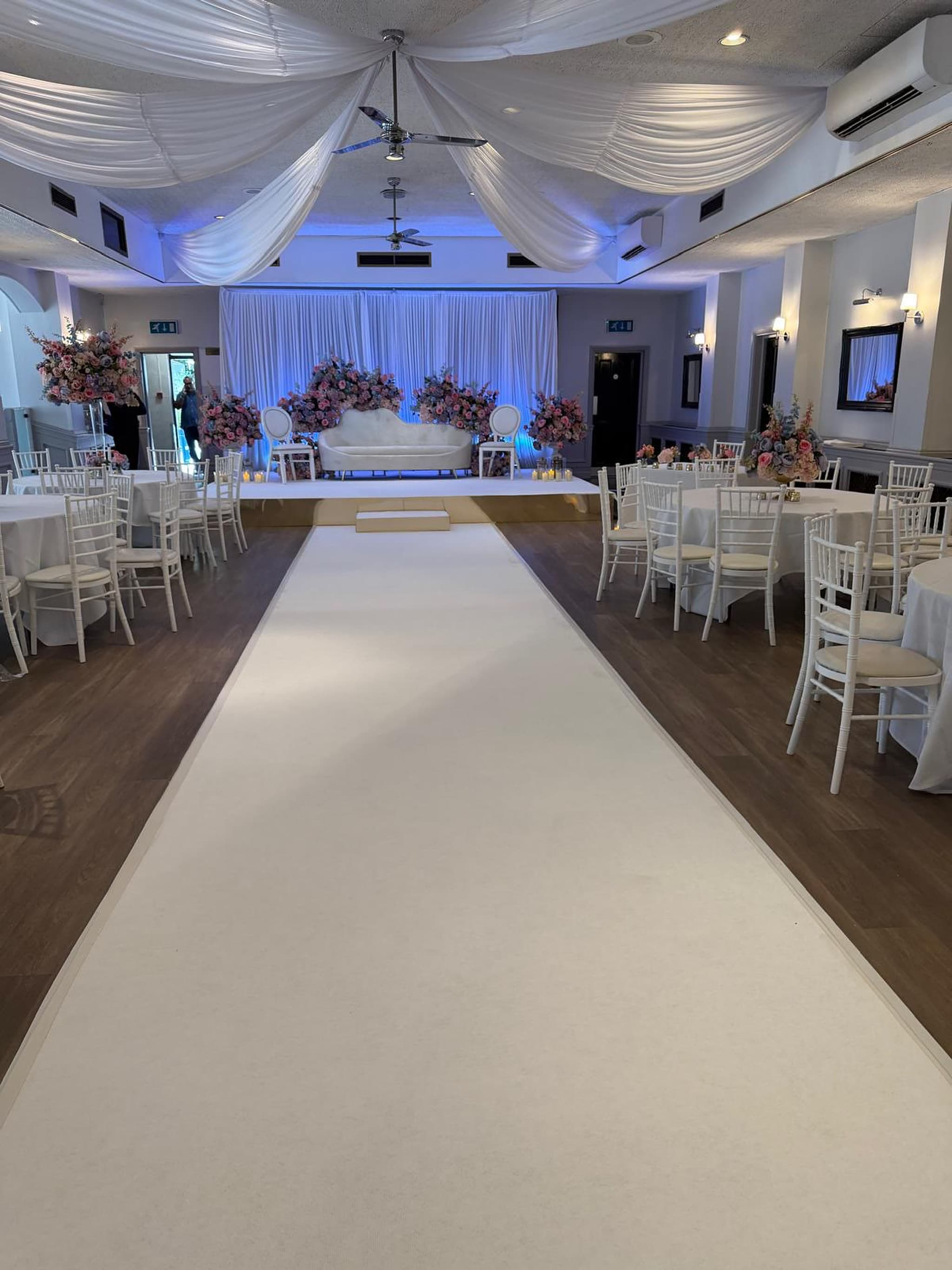 The Banqueting Suite at Chigwell Hall, set with a white aisle leading to the stage